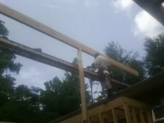 Carpenter setting a ridge beam over a new addition frame — Ice Dam Removal by Roofing Brothers in Rosalie